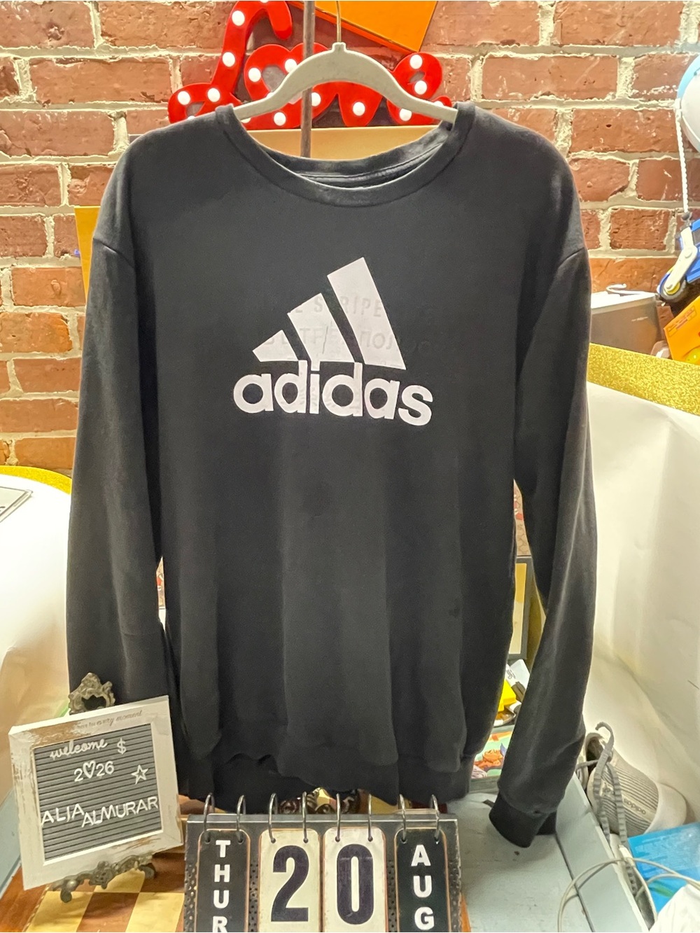 black Adidas crewneck fleece sweatshirt featuring a large white performance